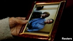 A picture of Junko Ishido and her son, journalist Kenji Goto, who is thought to be have been killed by Islamic State militants, is held by Ishido as she speaks to reporters at her house in Tokyo on January 30.