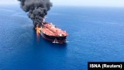 One of the two oil tankers is seen on fire in the sea off Oman on June 13.