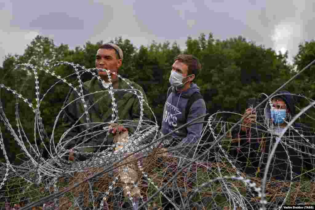 People stand behind barbed wire during the protests.