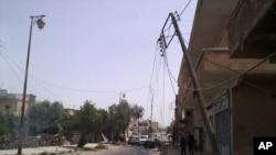 People walk a street strewn with debris in the southern city of Daraa.