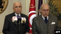 Tunisian Prime Minister Mohammed Ghannouchi (left) addresses the nation on state television, flanked by the interim president, Fouad Mebazza