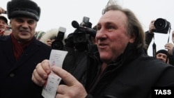 French actor Gerard Depardieu shows off his Russian passport after arriving at the airport in Saransk in Russia's Mordovia region on January 6.