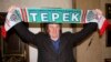 Actor Gerard Depardieu holds up a scarf of Terek Grozny soccer club as he poses for a picture during a visit to the Akhmat-Arena sports stadium in Grozny in February 2013.