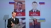 Wilbert Paulissen, one of the international investigators, speaks to reporters about the murder charges in front of photos of the suspects in Nieuwegein, the Netherlands, on June 19.