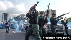 Members of the Bolivarian National Guard who support Venezuelan opposition leader Juan Guaido fire into the air to repel forces loyal to President Nicolas Maduro during clashes in Caracas on April 30. 