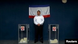 An official stands between two ballot boxes inside a polling station during the disputed referendum on the status of Ukraine's Crimea region in Bakhchisaray on March 16.