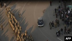 Egyptian soldiers are seen in Cairo's Tahrir Square, as people camping out in the square pack and leave on February 13.