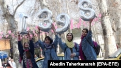 Iranian girls hold up numbers forming the Persian new year 1398 ahead of Norouz in Tehran on March 20.