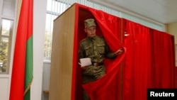 A soldier leaves a voting booth in Minsk to cast his ballot during early voting for Belarus's parliamentary elections.