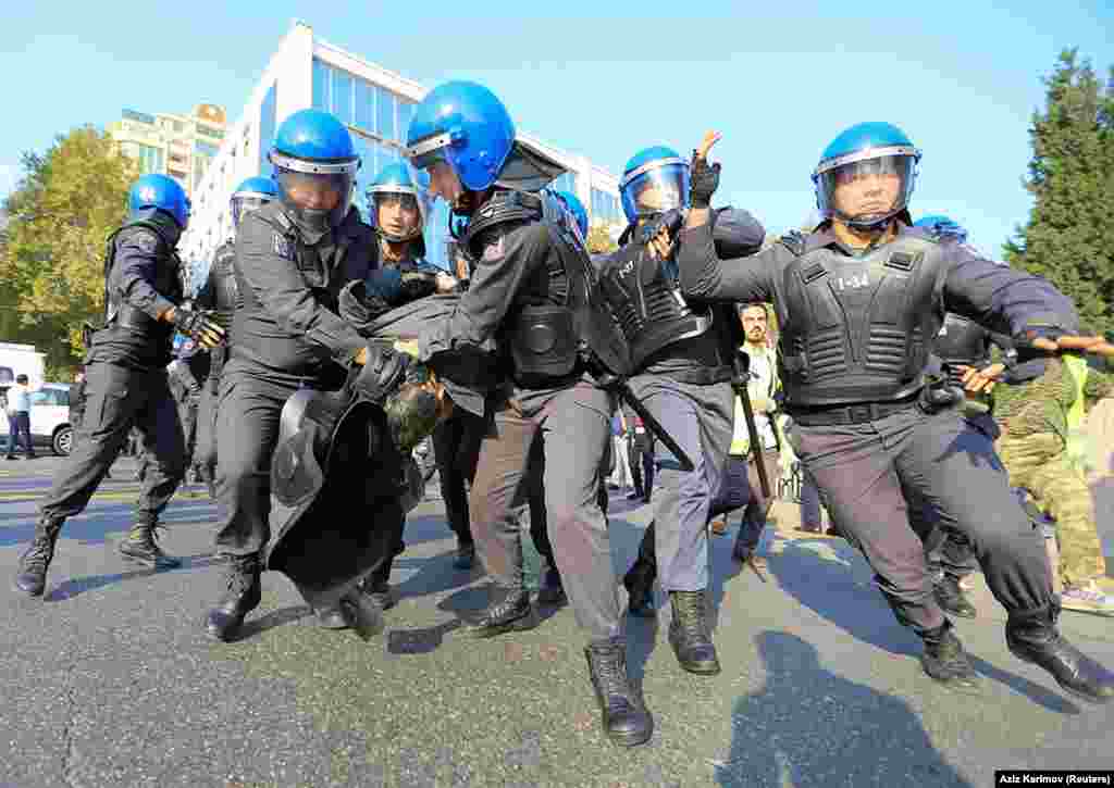 Azerbaijani police carry Keremli into custody. The authorities shut down several subway stations near the October 19 protest.