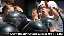 A protester objecting to the Russian-language bill gestures over the heads of riot police in downtown Kyiv on July 5.