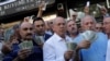 Istanbul workers hold up U.S. dollars outside of a currency exchange office. For Turkmen labor migrants, the dollar is the only major currency possible to transfer to Turkmenistan from abroad. (file photo)