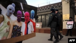 A supporter of the female punk band Pussy Riot holds a photo of a band while he and others picket police headquarters in Moscow on March 8.