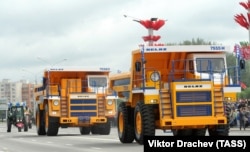 Two BelAZ quarry trucks rolling through Minsk during a military parade