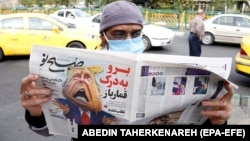 A man reads a copy of Iranian daily newspaper Sobhe Nou with a cartoon depicting U.S. President Donald Trump and a headline reading "Go to hell gambler" in Tehran on November 7.