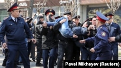 Kazakh police officers detain an anti-government protester during a rally in Almaty on March 22. 