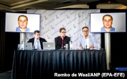 Bellingcat founder Eliot Higgins (center) presents a picture of Russian military officer Oleg Ivannikov at a press conference on May 25.