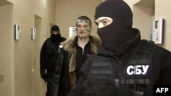 Adam Osmayev walks under escort of masked agents of the Ukrainian Security Service in Odesa.