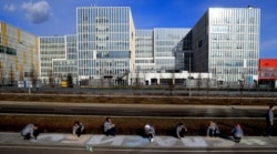 Activists write a slogan that reads "Thanks To Doctors" during a campaign to praise medical staff outside a hospital for patients infected with COVID-19 on the outskirts of Moscow on March 19.