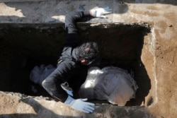 A man attends the funeral of a coronavirus victim at a cemetery just outside Tehran.