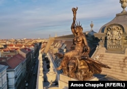 A lady of liberty sits atop an eagle on the corner of the New York Palace.