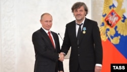 Bosnian-born Serb filmmaker Emir Kustarica (right) receives an award from Russian President Vladimir Putin in 2016.