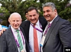 The president of the European Olympic Committee, Patrick Hickey (left), and Sports Minister Azad Rahimov pose with an unidentified man on June 11 in Baku.