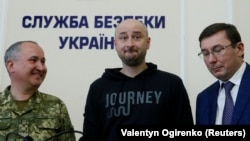 Arkady Babchenko (center) stands with Prosecutor-General Yuriy Lutsenko (right) and SBU chief Vasyl Hrytsak at a press briefing in Kyiv on May 29.