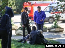 Rescuer workers help the injured outside the school.