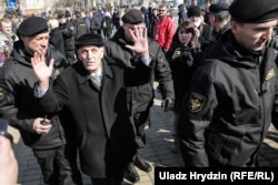 An elderly man is detained by police in Minsk.