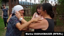 Biological mother Liana Khurtsidze (left) and adoptive mother Linda Stone embrace upon meeting in Dikhashkho, in western Georgia, on July 16.