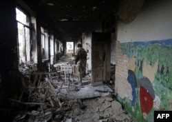 A Ukrainian serviceman walks through a destroyed school near Donetsk. (file photo)