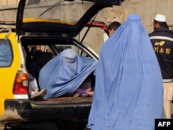 Afghan women wearing burqas sit in a taxi in Kabul.