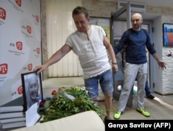 Babchenko (right) and the deputy chief of the Crimean Tatar channel ATR, Aider Muzhdabaiev, look at the memorial set up by Babchenko's colleagues after news of his death, in Kyiv on May 31.