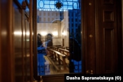 A riot policeman guards a side entrance to the church.