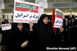 Iranian protesters hold anti-Israeli placards at a rally in Tehran on December 30.