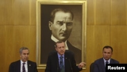 Prime Minister Recep Tayyip Erdogan, flanked by deputies Bulent Arinc (left) and Bekir Bozdag, calls for calm during a news conference in Istanbul on June 3.