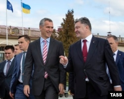 Ukrainian President Petro Poroshenko (right) speaks with NATO Secretary-General Jens Stoltenberg (left) during a welcoming ceremony in Lviv on September 21.