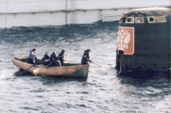 A group of workers approach the conning tower of the Kursk submarine, which was raised from the seafloor in 2001.