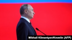 Russian President Vladimir Putin listens to the national anthem at the end of his annual state-of-the-nation address.