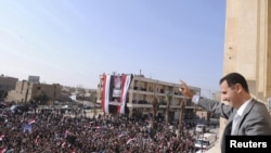 Syrian President Bashar al-Assad greets the crowd during a visit to Raqqa on November 6.