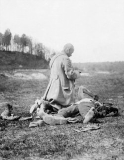 A priest tends to a dying Polish soldier.