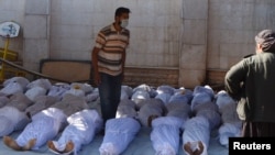 Activists inspect the bodies of people who died in a suspected chemical-gas attack in Damascus on August 21.