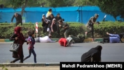 People rush for shelter as shooting starts during a military parade in the southwestern city of Ahvaz on September 22.