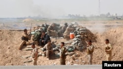 Kurdish Peshmerga forces clash with Islamic State militants in the town of Daquq, south of Kirkuk, on September 30.