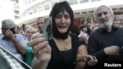 A woman holds a picture of her son, whom she says became an invalid from injuries sustained while in prison, during a protest rally in Tbilisi on September 19.