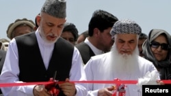 President Hamid Karzai (left) inaugurates a power plant north of Kabul in June with Mohammad Ismail Khan, who says he has Karzai's full support.