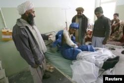 An Afghan man receives treatment in a Herat hospital after he was wounded in a suicide bombing in Farah Province in April.