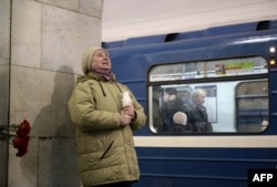 A woman reacts while placing flowers in honor of the victims of the April 3 blast on the platform of the Technological Institute subway station in St. Petersburg on April 4.