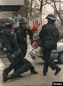 New York police arrest one of several dozen demonstrators who blocked streets by city hall to protest Mayor Ed Koch's AIDS policies on March 28, 1989.